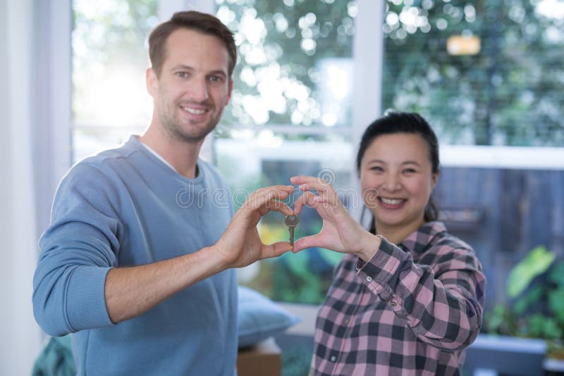 Pares sonrientes que hacen forma del corazón con las manos imagen de archivo