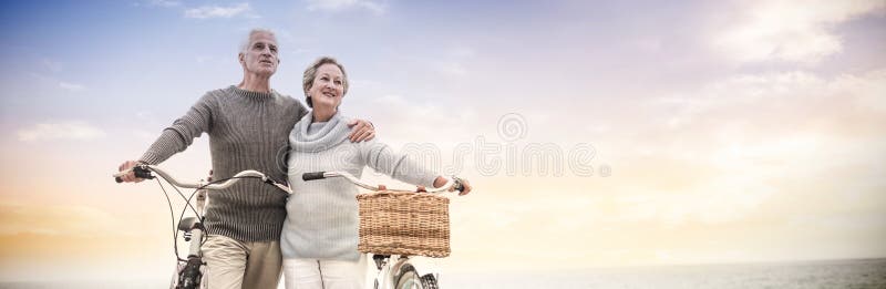 Pares superiores felizes com sua bicicleta imagens de stock royalty free