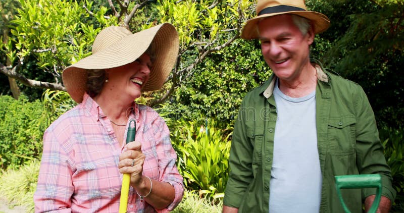 Pares superiores felizes que estão com ferramentas de jardinagem 4k