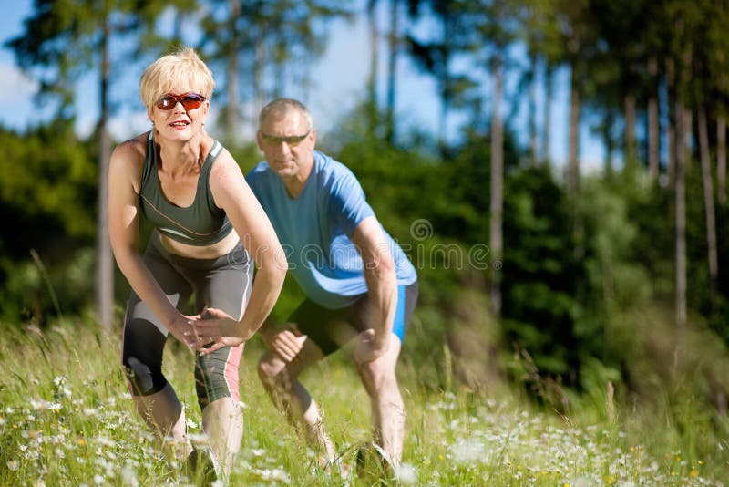Pares sênior que fazem o esporte que exercita ao ar livre imagens de stock royalty free Pares sênior que fazem o esporte que exercita ao ar livre imagens de stock royalty free