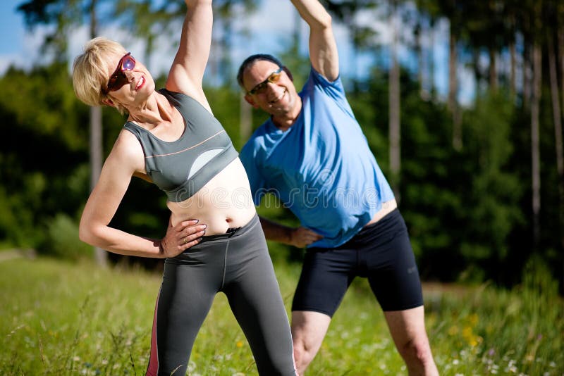 Pares sênior que fazem o esporte que exercita ao ar livre foto de stock Pares sênior que fazem o esporte que exercita ao ar livre foto de stock