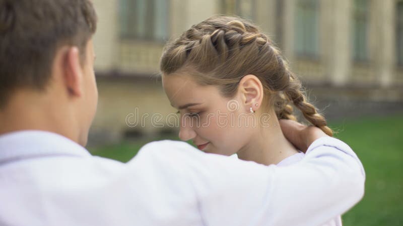 Pares tímidos de adolescentes que abraçam-se, primeiro amor, relacionamento da proposta