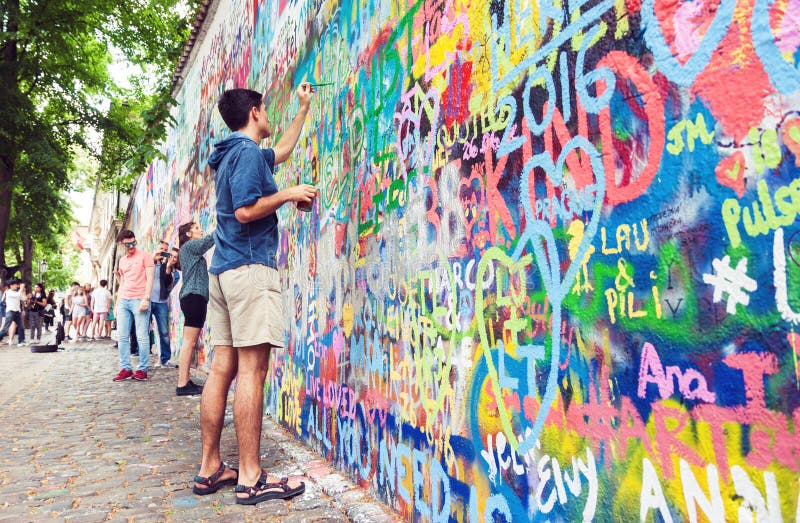 Giovane che dipinge un muro con graffiti fotografia stock libera da diritti