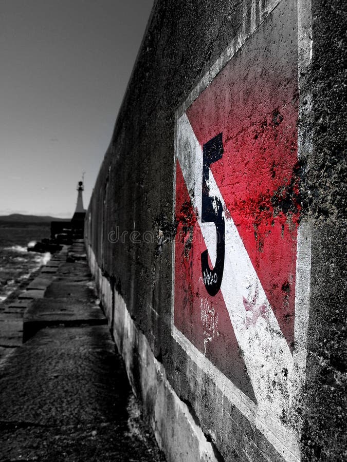 The number 5 painted on a dark wet cement wall on a dark day, Victoria Harbor, Canada. The number 5 painted on a dark wet cement wall on a dark day, Victoria Harbor, Canada.