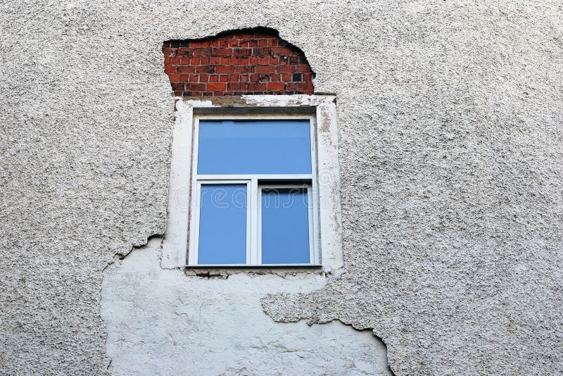 Parete rovinata che affronta intorno alla struttura della finestra recentemente installata fotografie stock libere da diritti Parete rovinata che affronta intorno alla struttura della finestra recentemente installata fotografie stock libere da diritti