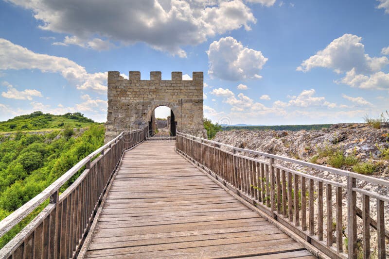 Pareti di pietra e portone con il ponte di legno sulla fortezza medievale immagine stock Pareti di pietra e portone con il ponte di legno sulla fortezza medievale immagine stock