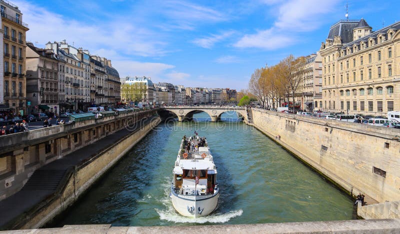 Parijs/Frankrijk - April 5, 2019: Mooie cityscape van Parijs, Saint-Michelbrug over Zegenrivier en een toeristenschip met touri stock foto Parijs/Frankrijk - April 5, 2019: Mooie cityscape van Parijs, Saint-Michelbrug over Zegenrivier en een toeristenschip met touri stock foto