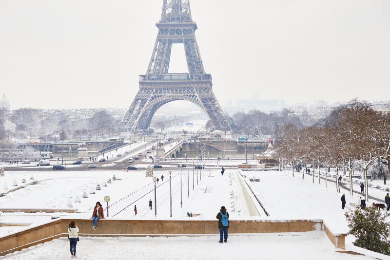 PARIJS, FRANKRIJK - FEBRUARI 7, 2018: toeristen die van toneelmening genieten aan de toren van Eiffel op een dag met zware sneeuw