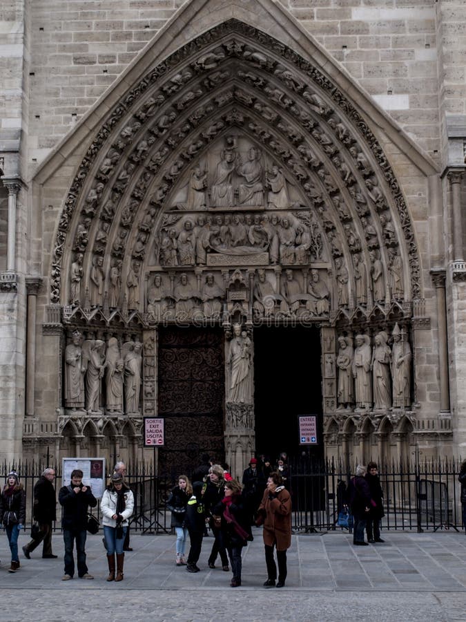 Paris, Fran?a 22 de fevereiro de 2013: Fragmento da eleva??o dianteira com a entrada ? catedral de Notre Dame em Paris fotografia de stock royalty free Paris, Fran?a 22 de fevereiro de 2013: Fragmento da eleva??o dianteira com a entrada ? catedral de Notre Dame em Paris fotografia de stock royalty free