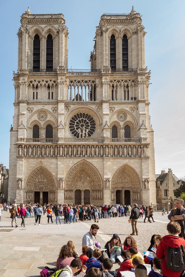 Paris, France, March 27, 2017: School group excursion following the lesson of the tour guide near the western facade of stock photos Paris, France, March 27, 2017: School group excursion following the lesson of the tour guide near the western facade of stock photos