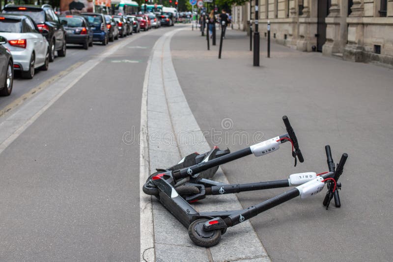 PARIS, FRANCE - MAY 25, 2019: Scooter kicksharing lying on the sidewalk. Scooter startups have flooded the city`s royalty free stock images PARIS, FRANCE - MAY 25, 2019: Scooter kicksharing lying on the sidewalk. Scooter startups have flooded the city`s royalty free stock images