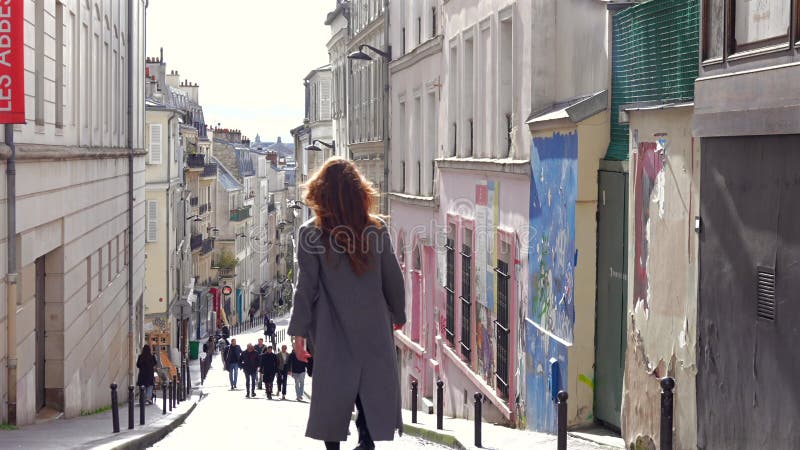 Paris France 04012025 Retour vue d'une femme se promenant dans la rue pavée éclairée banque de vidéos