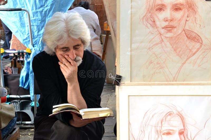 PARIS/FRANCES - 24 septembre 2011 : L'artiste a lu un livre dans Montmartre, le secteur de Bohème légendaire d'artiste de Paris À image stock PARIS/FRANCES - 24 septembre 2011 : L'artiste a lu un livre dans Montmartre, le secteur de Bohème légendaire d'artiste de Paris À image stock