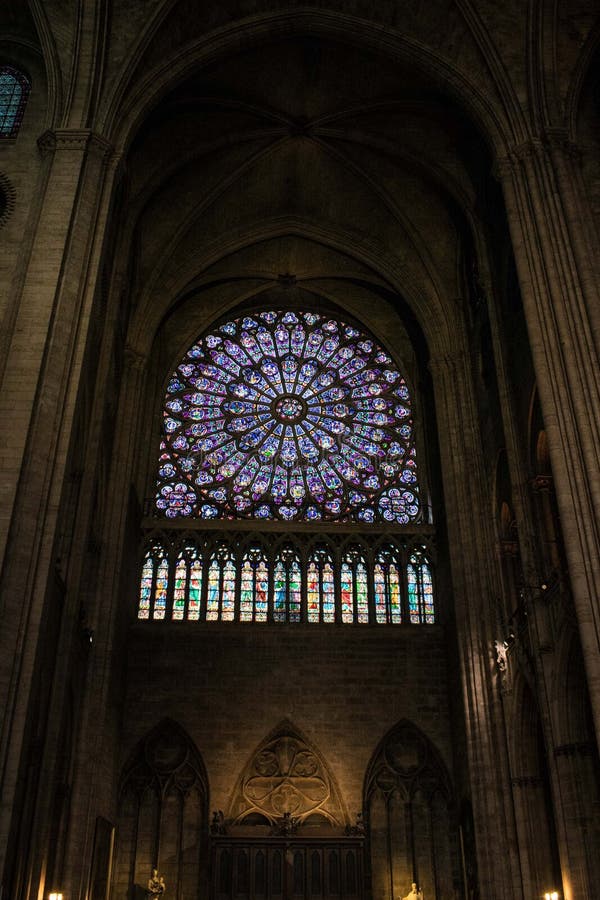 Paris, France - April 1, 2019: Rose stained glass window of Notre Dame Cathedral, Paris. Paris, France - April 1, 2019: Rose stained glass window of Notre Dame Cathedral, Paris