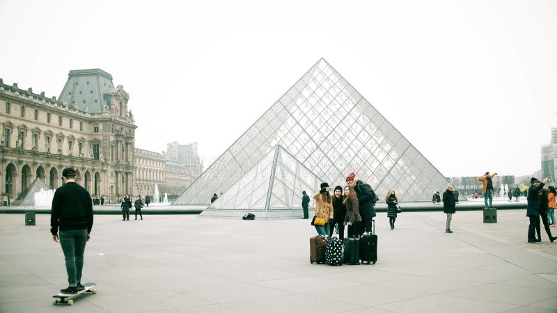 PARIS FRANKRIKE - DECEMBER, 31, 2016 Ungdomarsom gör selfie nära Louvre, det berömd franska museet och populärt arkivbild PARIS FRANKRIKE - DECEMBER, 31, 2016 Ungdomarsom gör selfie nära Louvre, det berömd franska museet och populärt arkivbild