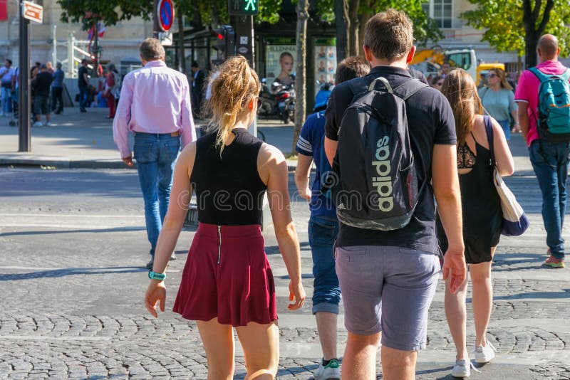 PARIS, FRANKRIKE - 23 JUNI, 2017: Okända ungdomar som korsar en övergångspromenad i centrala Paris på Avenue des Champs-Elysee royaltyfri fotografi PARIS, FRANKRIKE - 23 JUNI, 2017: Okända ungdomar som korsar en övergångspromenad i centrala Paris på Avenue des Champs-Elysee royaltyfri fotografi