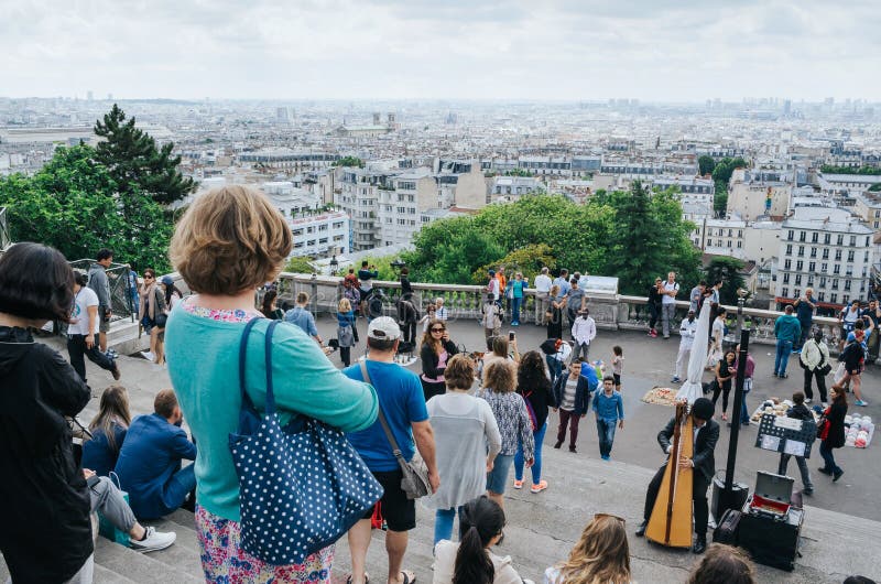 PARIS, FRANÇA - 26 DE JUNHO DE 2016: Turistas perto da catedral de Sacre Ceour de Montmartre Vista da cidade do ponto de vista do fotografia de stock royalty free PARIS, FRANÇA - 26 DE JUNHO DE 2016: Turistas perto da catedral de Sacre Ceour de Montmartre Vista da cidade do ponto de vista do fotografia de stock royalty free