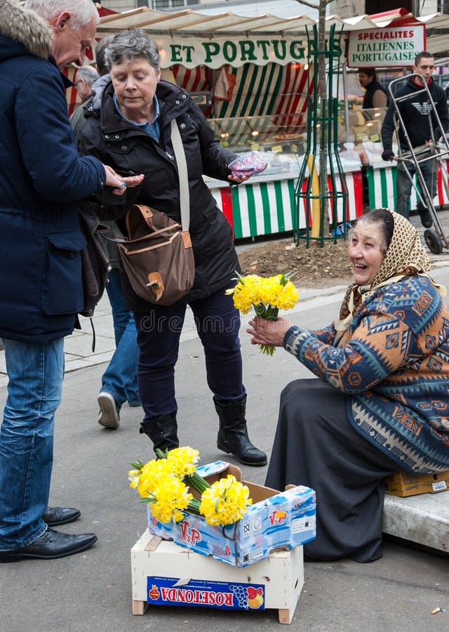 Lächelnde ältere Frau verkauft gelbe narcissuses an Käufer am Markt stockfotografie Lächelnde ältere Frau verkauft gelbe narcissuses an Käufer am Markt stockfotografie