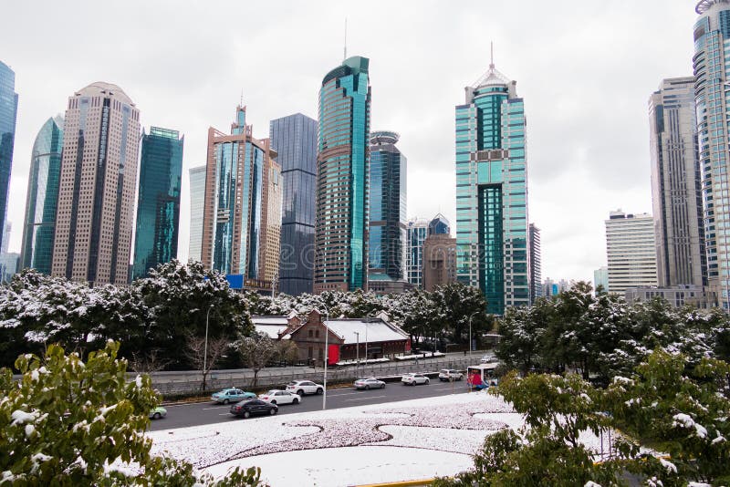 Park met bomen en weg met sneeuw wordt door wolkenkrabbers in het Pudong-gebied wordt omringd behandeld dat Shanghai, China stock afbeelding Park met bomen en weg met sneeuw wordt door wolkenkrabbers in het Pudong-gebied wordt omringd behandeld dat Shanghai, China stock afbeelding