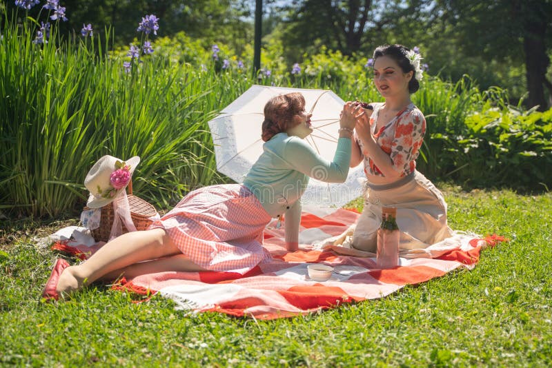 Parkerar nätt stift två upp damer som har den trevliga picknicken i staden, i en solig dag tillsammans flickavänner tycker om var arkivbild Parkerar nätt stift två upp damer som har den trevliga picknicken i staden, i en solig dag tillsammans flickavänner tycker om var arkivbild