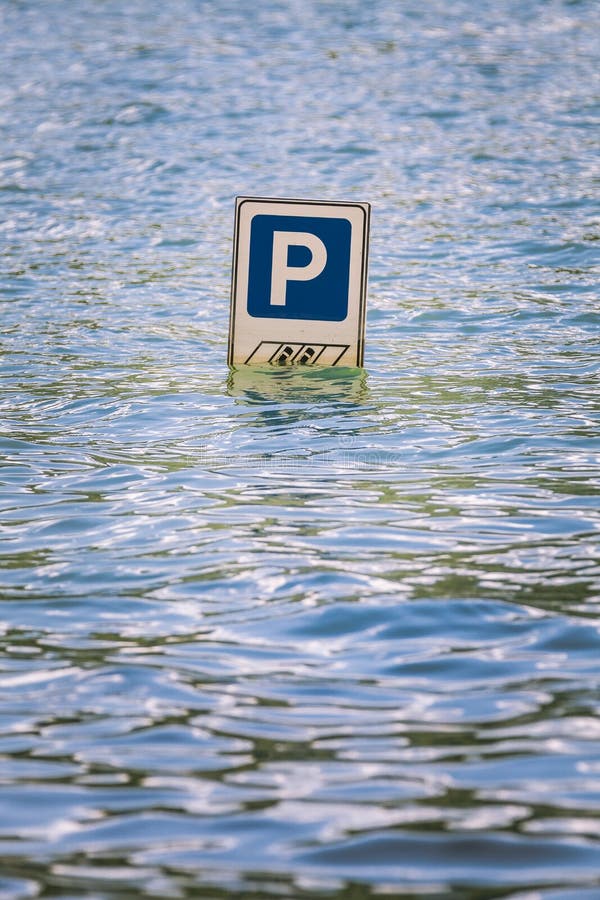 Parking samochodów drogowy znak stronniczo zanurzał w powodzi obraz stock