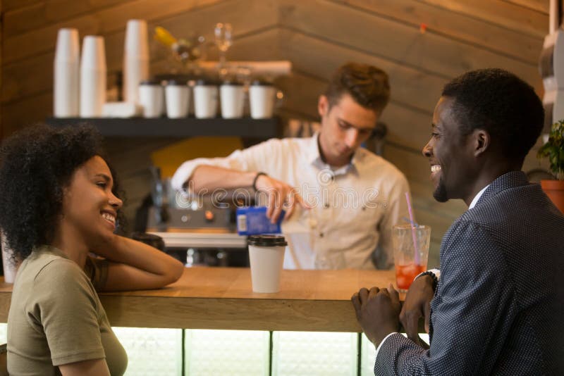 Parler de flirt d'homme et de femme d'afro-américain au Ba de coffeeshop photo stock Parler de flirt d'homme et de femme d'afro-américain au Ba de coffeeshop photo stock
