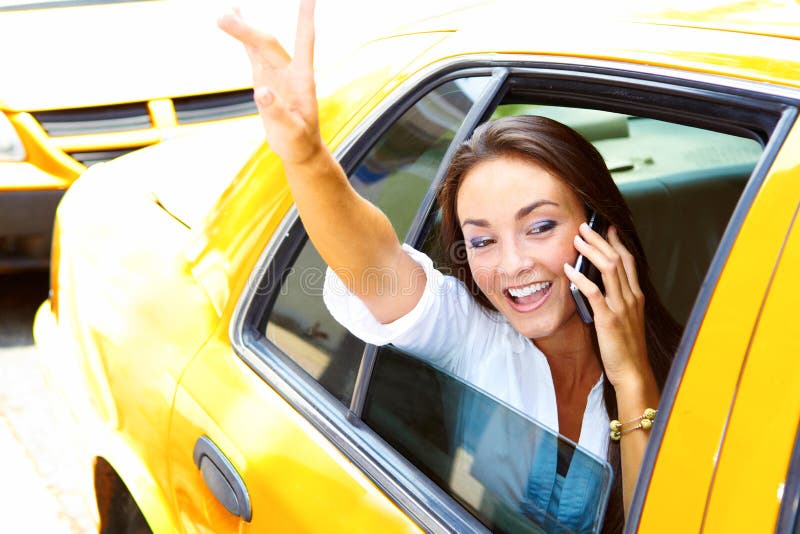 Parler femelle de belles jeunes affaires au téléphone portable dans le taxi images libres de droits Parler femelle de belles jeunes affaires au téléphone portable dans le taxi images libres de droits