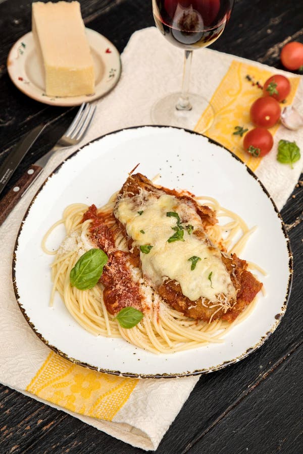 Parmigiana del pollo servito sopra gli spaghetti con la salsa di marinara fotografia stock libera da diritti Parmigiana del pollo servito sopra gli spaghetti con la salsa di marinara fotografia stock libera da diritti