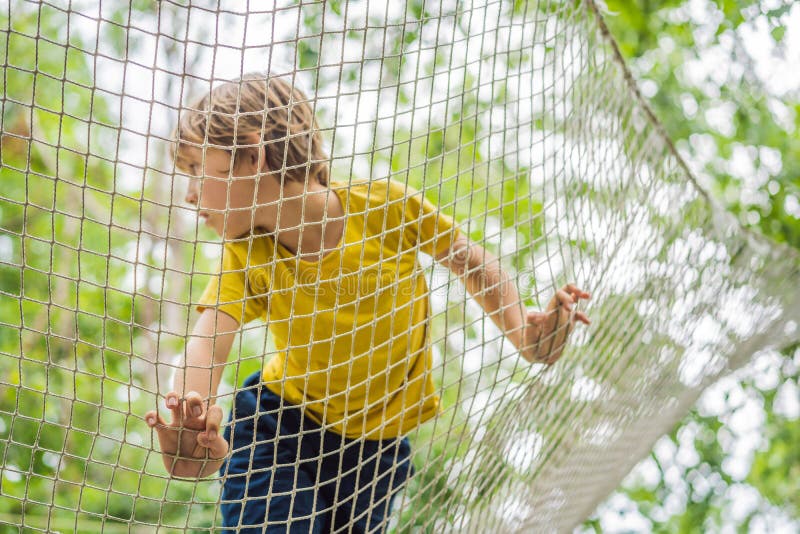 Parque Infantil De Redes De Práctica. Niño Juega En El Patio De Recreo  Protegido Con Una Red De Seguridad. Concepto De Niños En Lí Foto de archivo  - Imagen de sobrecarga, felicidad