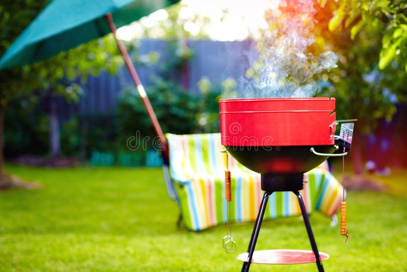 Parrilla de la barbacoa con humo en partido del patio trasero del verano fotos de archivo Parrilla de la barbacoa con humo en partido del patio trasero del verano fotos de archivo