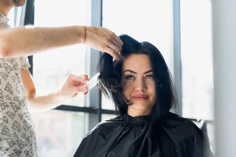 Parrucchiere professionista, stilista che pettina capelli del cliente femminile nel salone di capelli professionale Bellezza e co fotografia stock libera da diritti Parrucchiere professionista, stilista che pettina capelli del cliente femminile nel salone di capelli professionale Bellezza e co fotografia stock libera da diritti