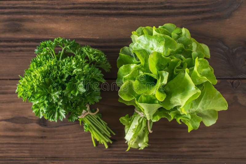 Parsley and Lettuce Leaves in Bunches on the Table. Flat Lay. Stock