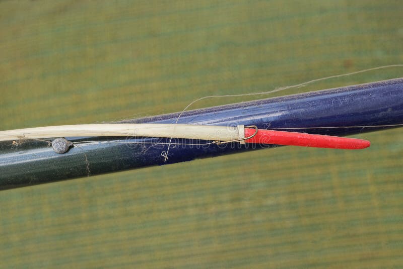 Part of a Blue Plastic Fishing Rod with a Long Red White Float on