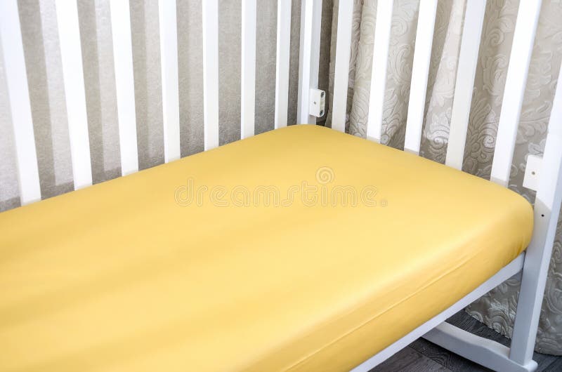 Part of Cot, Close Up. Mattress and Yellow Sheet in White Bed. Stock Photo Image of crate