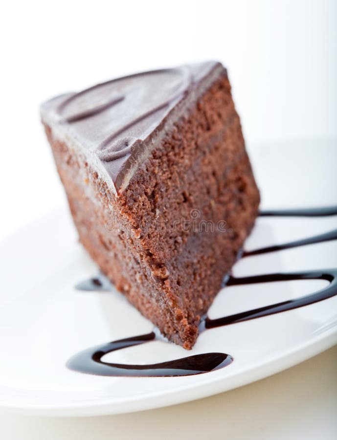 Slice of delicious chocolate cake with chocolate sauce on a white plate. Slice of delicious chocolate cake with chocolate sauce on a white plate