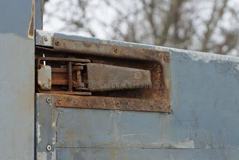Part of an iron dirty side of a truck with a large brown latch stock photography