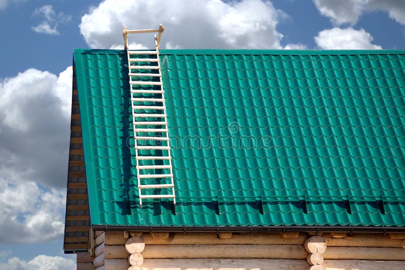 Part of new country house from logs and green metal tile roof