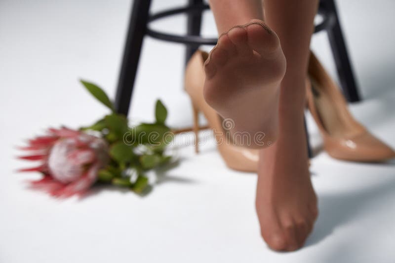 Part of woman body perfect shape legs feet skin tan wear stockings, nylons, pantyhose lingerie hosiery hose studio shot. on white