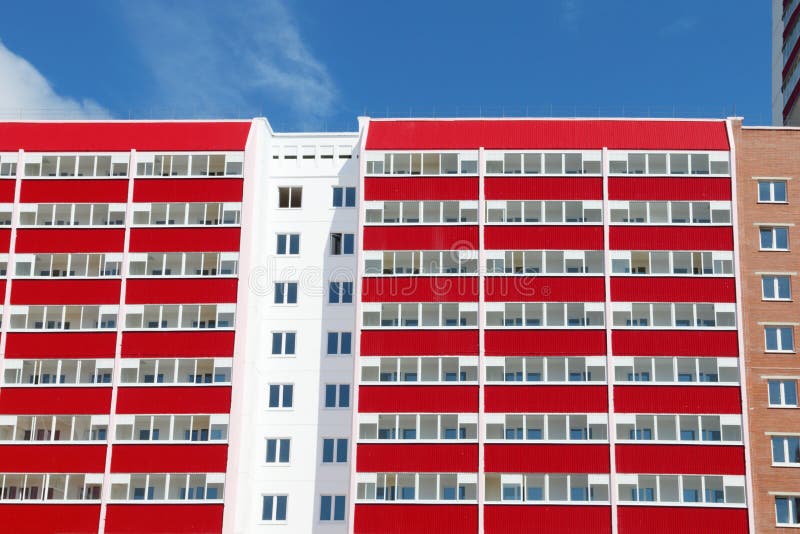 Parte de edificio residencial con muchas logias rojas en soleado foto de archivo Parte de edificio residencial con muchas logias rojas en soleado foto de archivo