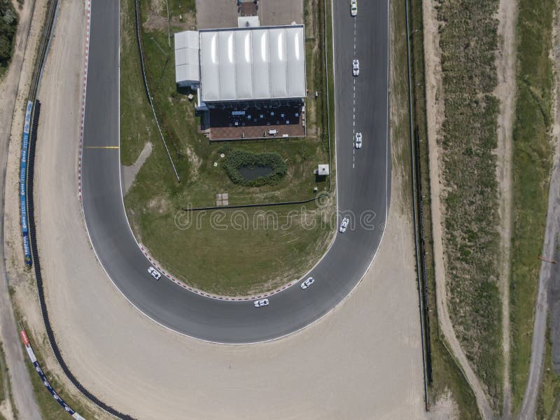 Parte superior abaixo da vista aérea da curva no circuito de autódromo do esporte automóvel com borda da estrada da areia fotos de stock Parte superior abaixo da vista aérea da curva no circuito de autódromo do esporte automóvel com borda da estrada da areia fotos de stock