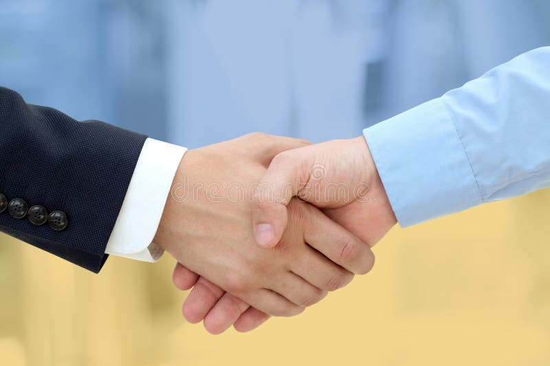 Business partners shaking hands in reconciliation. Ukraine flag is behind. Business partners shaking hands in reconciliation. Ukraine flag is behind.