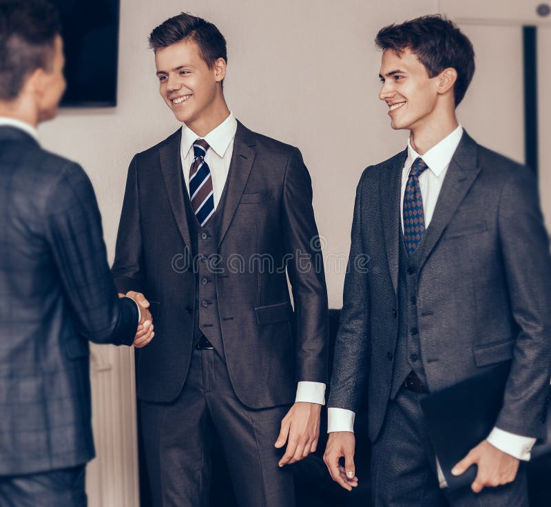 Parteneri comerciali strânși de mână în sala de reuniune a centrului de afaceri royalty free stock images