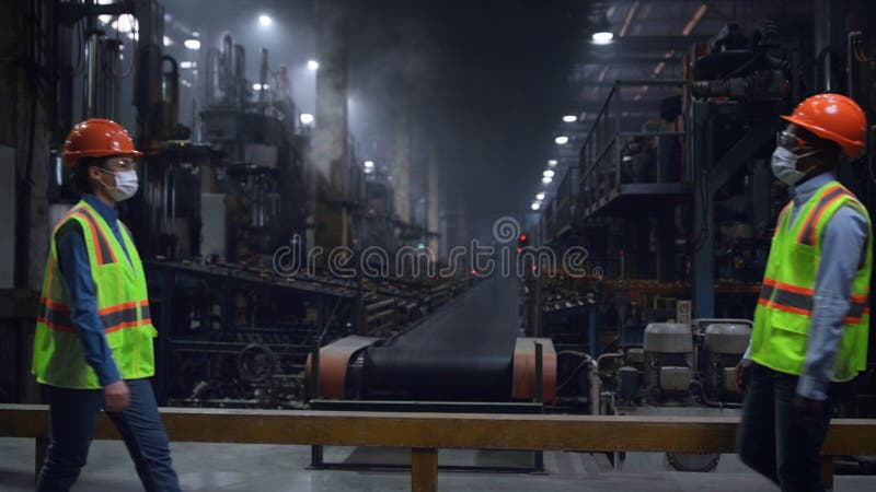 Parteneri ingineri industriali salutând purtarea unei măști de siguranță la fabrică. stock photos