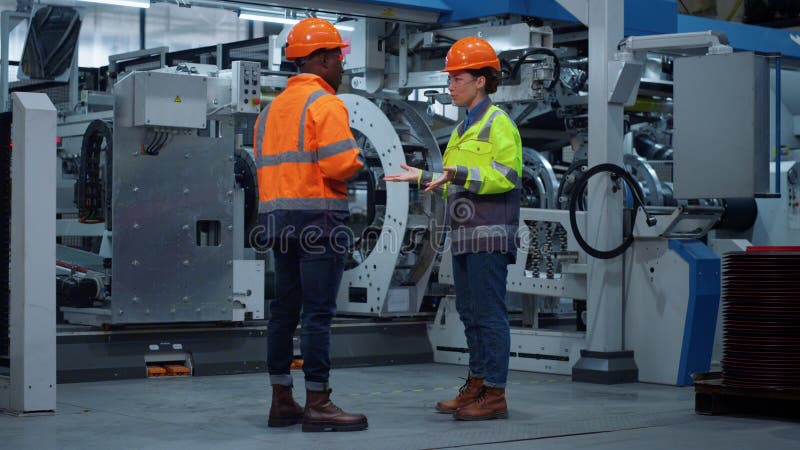 Partenerii mecanici strângând mâna aproape de imense construcții industriale moderne. royalty free stock photos