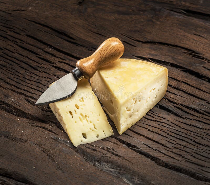 Pedaços de queijo caseiro sobre um fundo de madeira imagens de stock royalty free