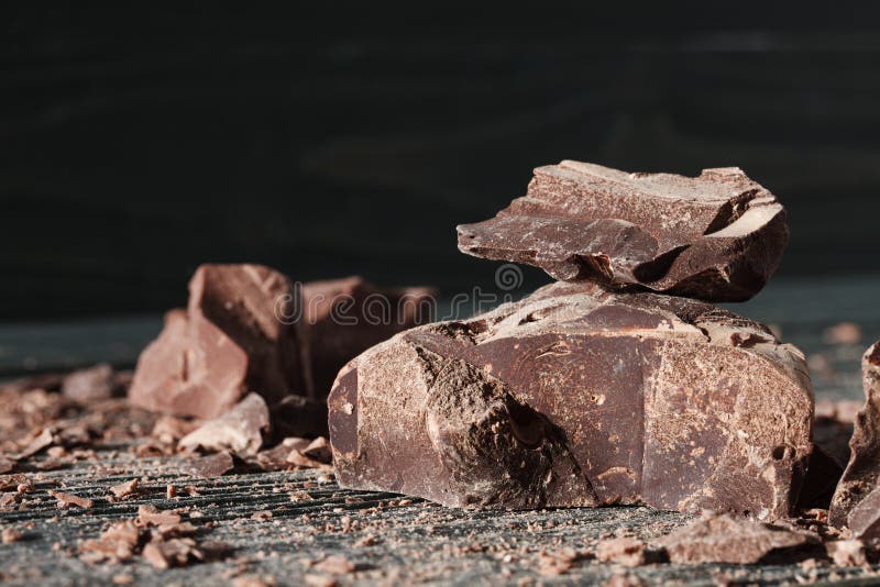 Partes do chocolate em um backround escuro foto de stock royalty free Partes do chocolate em um backround escuro foto de stock royalty free