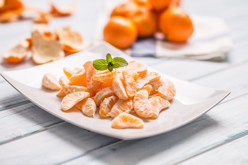 Partes frescas do mandarino das tangerinas na placa ou em uma bacia imagens de stock Partes frescas do mandarino das tangerinas na placa ou em uma bacia imagens de stock