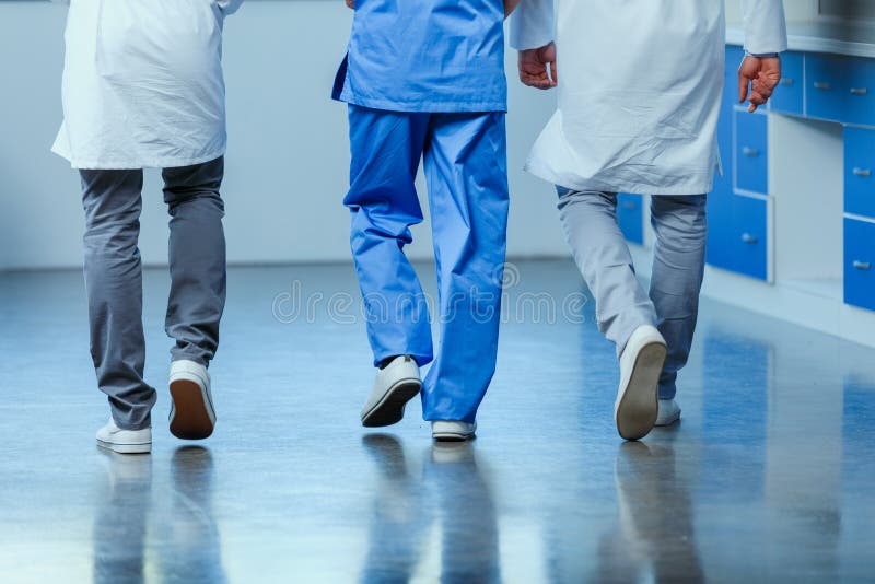 Partial view of group of doctors walking in clinic stock photo