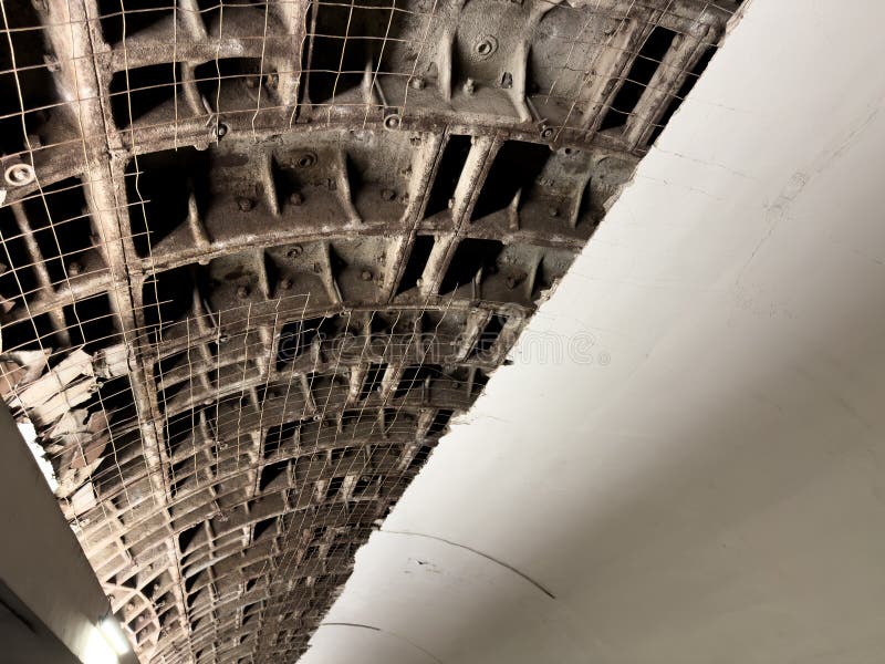Partially damaged ceiling with visible metal supports for circular roof structure and white trim ceiling. The ceiling is stock image