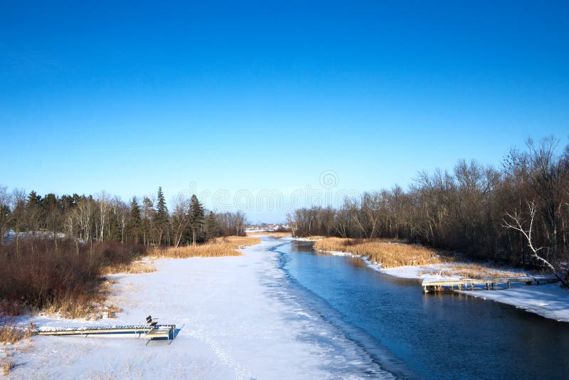 Partially frozen Mississippi River and boat docks in winter in Bemidji, MN